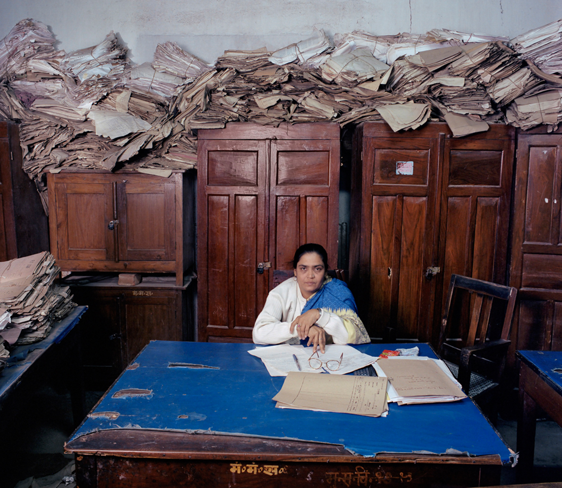 Woman in office surrounded by papers. Photo