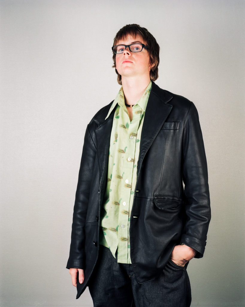 Portrait og a young boy wearing black leather jacket and glasses