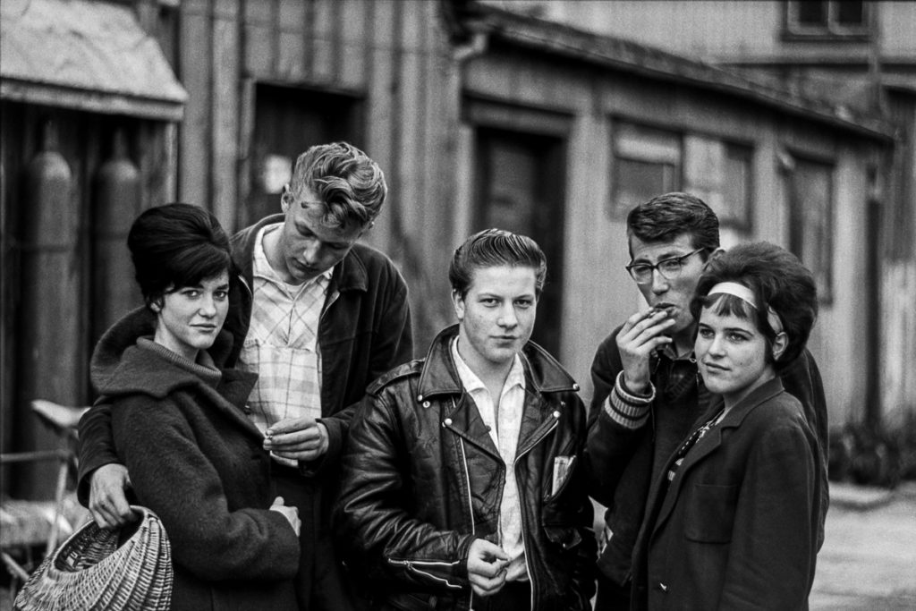 Black an white photograph of five youths in sixties attire. 