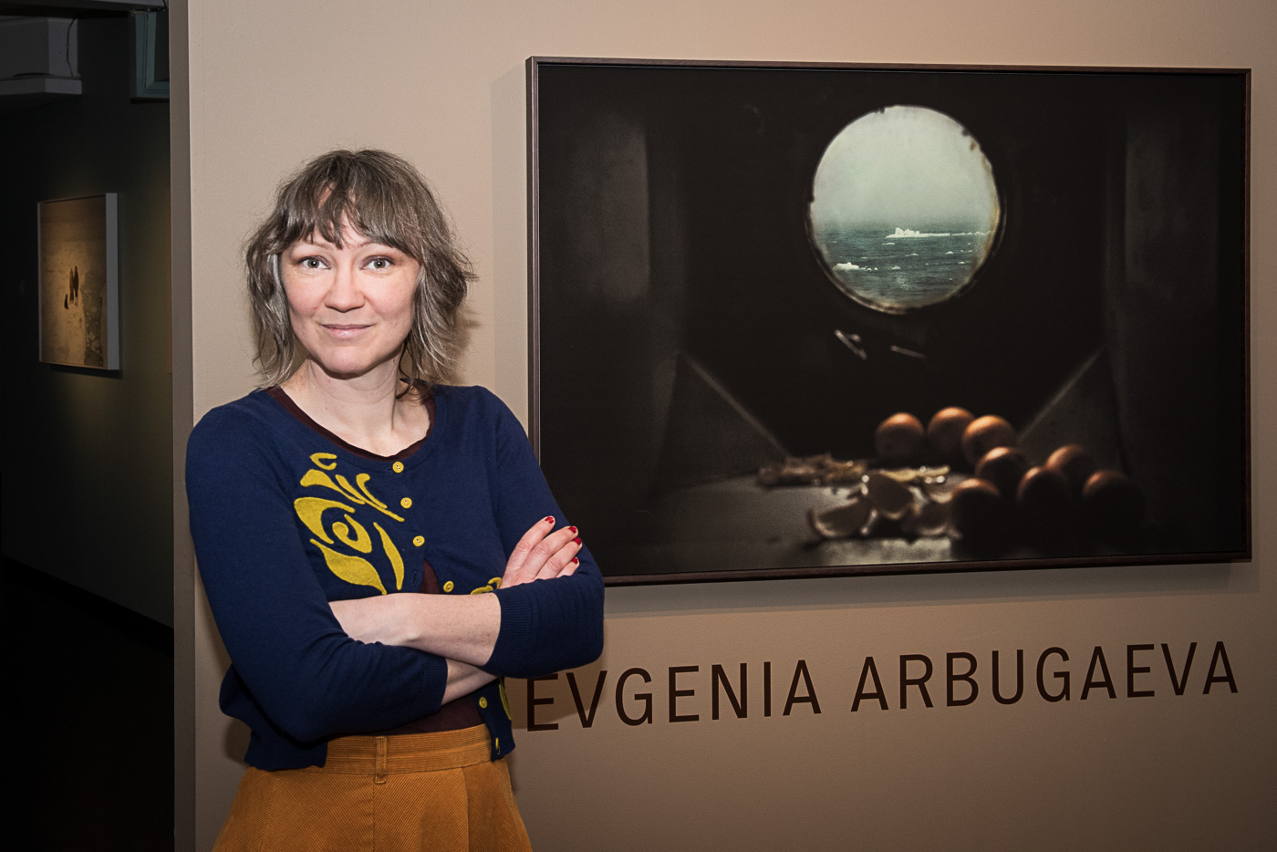 Woman stands in front of framed image