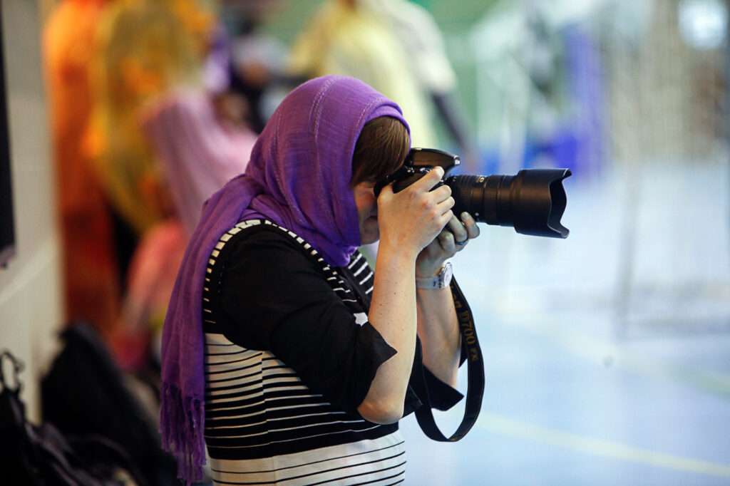 dame med tildekket hår fotograferer