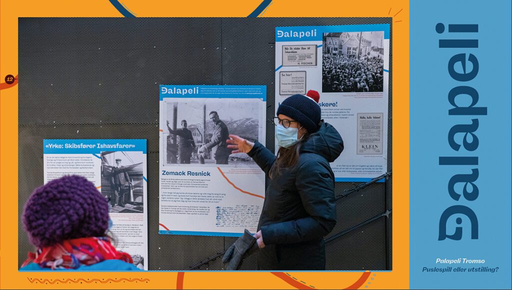 Dame med munnbind omviser i utstillingen innendørs